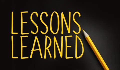 Lessons Learned text in yellow on black and pencil besides. Education or risk 库存照片