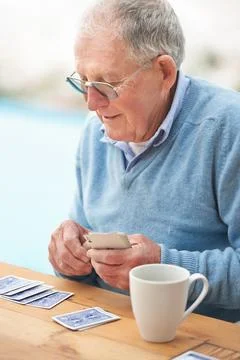 Let the games begin. a senior man holding a deck of cards. Stock Photos