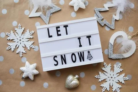 Let it snow text around Christmas ornaments. Christmas decorations on dot basic Stock Photos