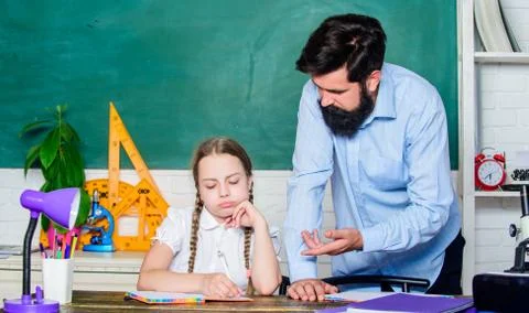 Let me help you. bearded man teacher with small girl in classroom. daughter Foto stock