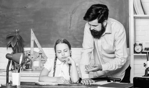 Let me help you. bearded man teacher with small girl in classroom. daughter Foto stock