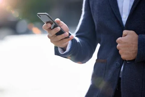 Let me know when you arrive. a businessman using his smartphone to send a text. Stock Photos
