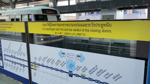 "Let passengers exit first and be careful of the closing doors" sign at platform Stock Footage 183544064