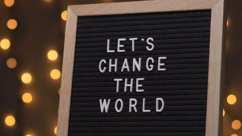 LET S CHANGE THE WORLD Words on a Black Letter Board Message Sign Stock Footage