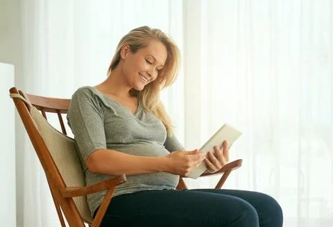 Let technology be your guide through the process. Shot of a pregnant woman using Foto stock