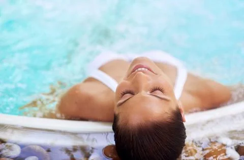 Let your worries just float away.... Shot of a young woman relaxing at a spa  Stock Photos