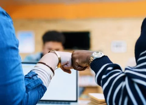 Lets ace these finals. Rearview shot of two students fist bumping in the library Stock Photos