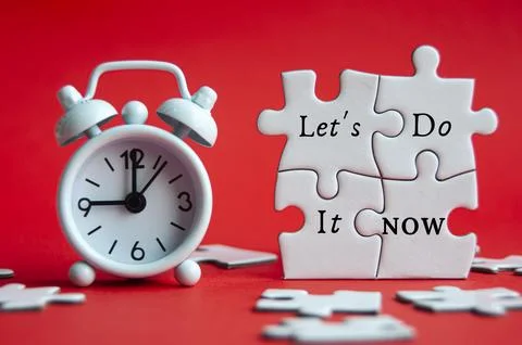 Let's do it now text on jigsaw puzzle with alarm clock pointing at 9 am on .. Stock Photos