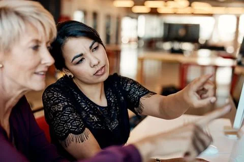 Lets explore that. two businesswomen using a computer together in a modern Foto stock