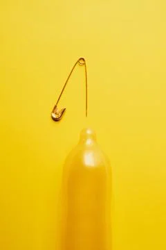 Lets get to the point. Studio shot of a condom with a sharp needle on top of it Stock Photos