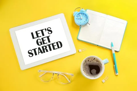 Let's Get Started. Flat lay composition with tablet and stationery on yellow  스톡 사진