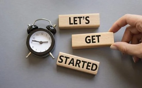 Lets get started symbol. Concept words Lets get started on wooden blocks. B.. Stock Photos