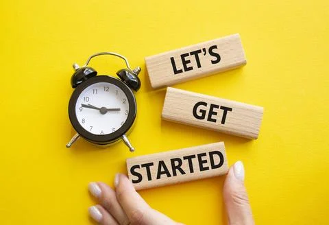 Lets get started symbol. Concept words Lets get started on wooden blocks. B.. Stock Photos