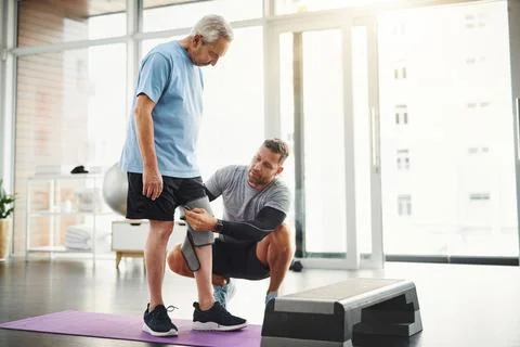 Lets get your body back to functioning 100. a young male physiotherapist Stock Photos
