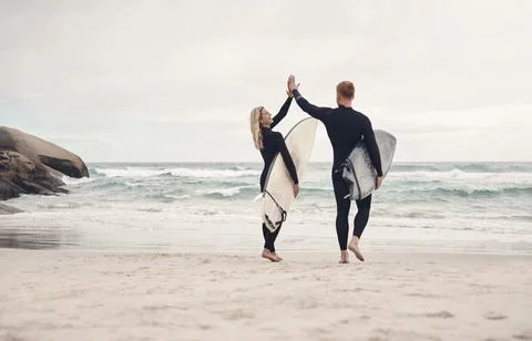 Lets go catch some waves, babe. a couple giving each other a high five while out Stock Photos