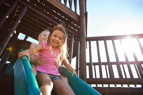 Lets have some fun. two little girls on a slide at the play park. Fotos Stock