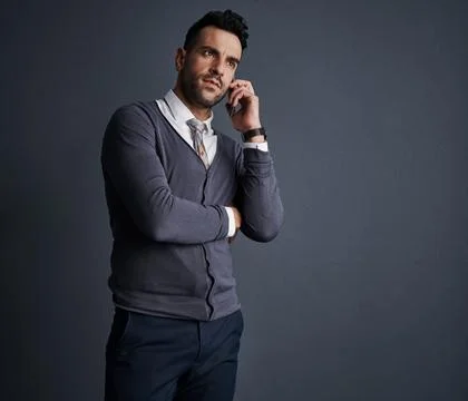 Lets make it happen. Studio shot of a stylish young businessman using a mobile Stock Photos