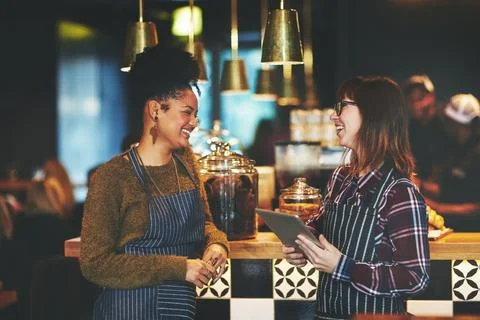 Lets make a loyalty program available to our customers. two young women using a Stock Photos