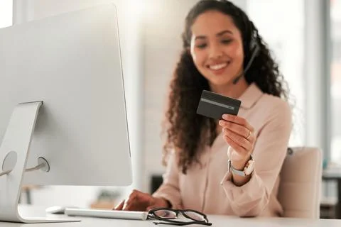 Lets make a quick payment. a young female call center agent using a credit card Stock Photos