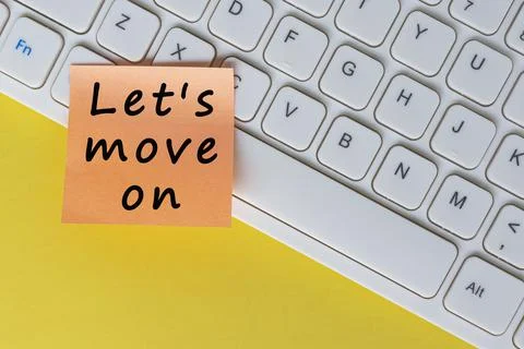Let's move on text on orange sticky note on top of white keyboard. Stock Photos