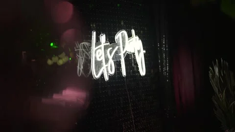 Let’s party neon sign at elegant event decoration glowing in night interior Stock Footage 327692858