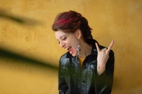 Let's rock concept. Side view of excited beautiful woman with dark pink hair in Foto stock