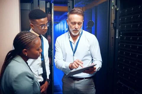 Lets run a virus scan. a group of technicians using a digital tablet while Stock Photos