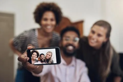 Lets snap some selfies for our business profile. a group of businesspeople Stock Photos