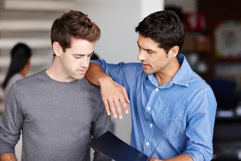 Lets solve these problems together. Two friendly colleagues discussing a Stock Photos