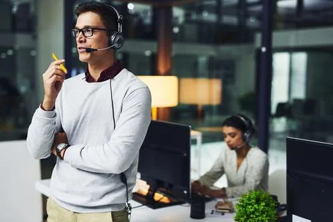 Lets solve your problems one by one.... Shot of a young call centre agent wor 写真素材