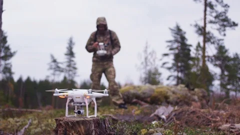 Lets start a drone in the middle of a forest, controlled by a man full in Stock Footage 89349514