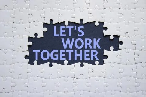 Lets work together symbol. Concept words Lets work together on white puzzle.. Stock Photos