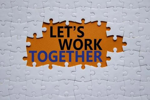 Lets work together symbol. Concept words Lets work together on white puzzle.. Stockfoto's