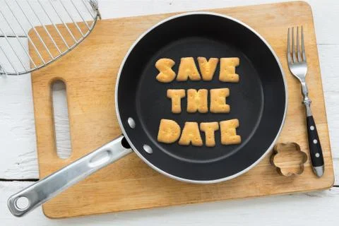 Letter biscuits quote SAVE THE DATE and cooking equipments. Stock Photos