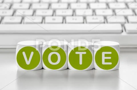 Letter dice in front of a keyboard - Vote Stock Photos