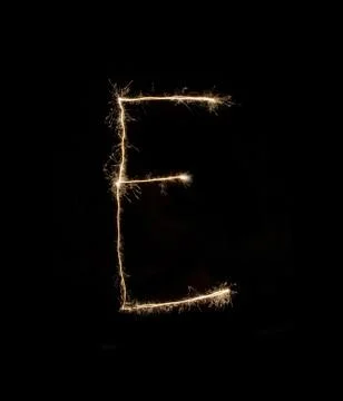 Letter E drew with spakrs on a black background. Stock Photos