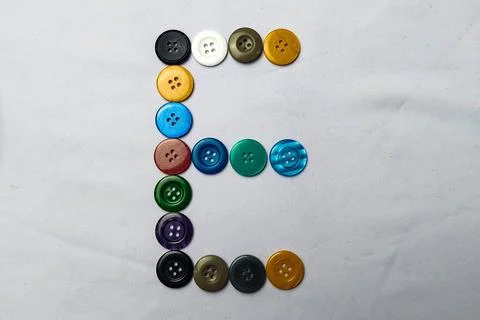 The letter E is made up of shirt buttons. Stock Photos