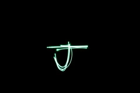 Letter J written with light paint photography technique on black background.  Stock Illustration