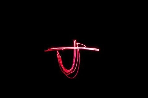 Letter J written with light paint photography technique on black background.  Stock Illustration