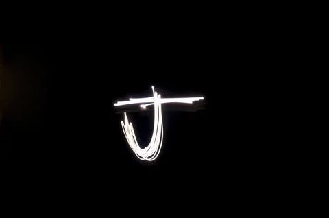 Letter J written with light paint photography technique on black background.  Stock Illustration