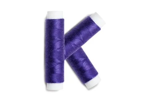 Letter of K from thread spools, isolated on white background. Alphabet concep Stock Photos