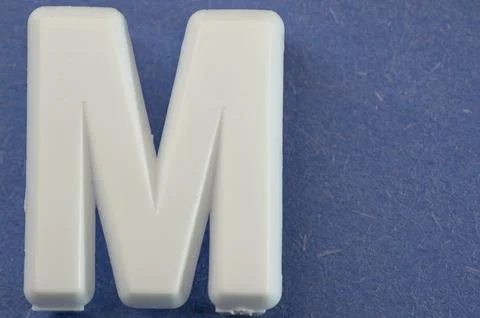 Letter M on a blue background Stock Photos