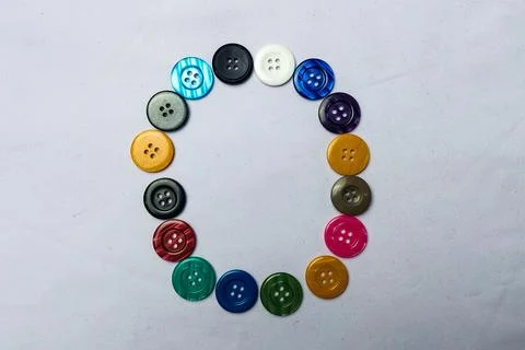 The letter O is made up of shirt buttons. Stock Photos