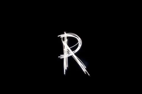 Letter R written with light paint photography technique on black background.  Stock Illustration