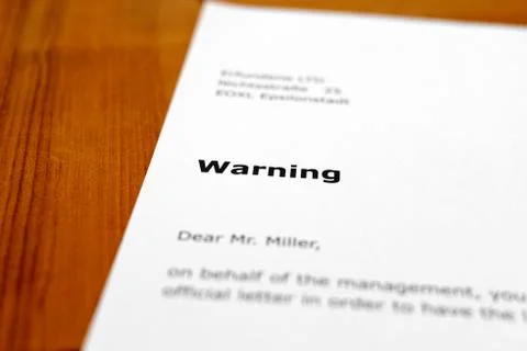 A letter on a wooden table - warning Stock Photos