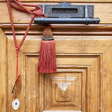 Letterbox and handle on brown solid wood door closeup with red cord Foto stock