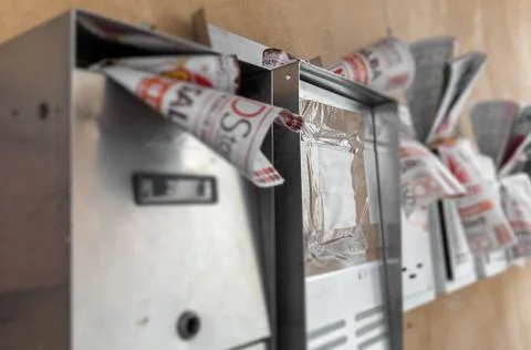 Letterboxes full of junk mails Stock Photos
