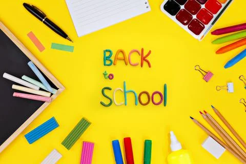 Lettering of multi-colored plasticine back to school and black chalk board an Stock Photos