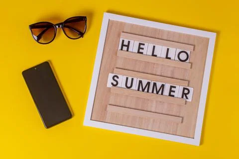 Lettering on the post board HELLO SUMMER on an isolated yellow textured backg Stock Photos