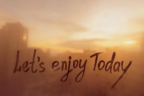 Lettering text Lets enjoy Today painted on window flooded with raindrops on Stock Photos
